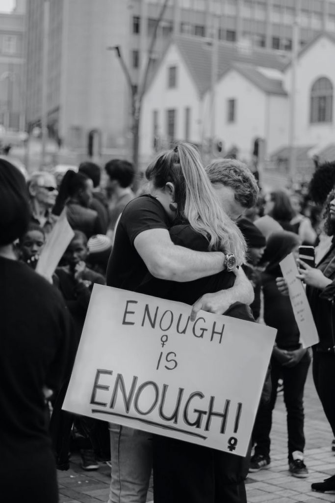 couple hugging and holding sing with enough is enough inscription