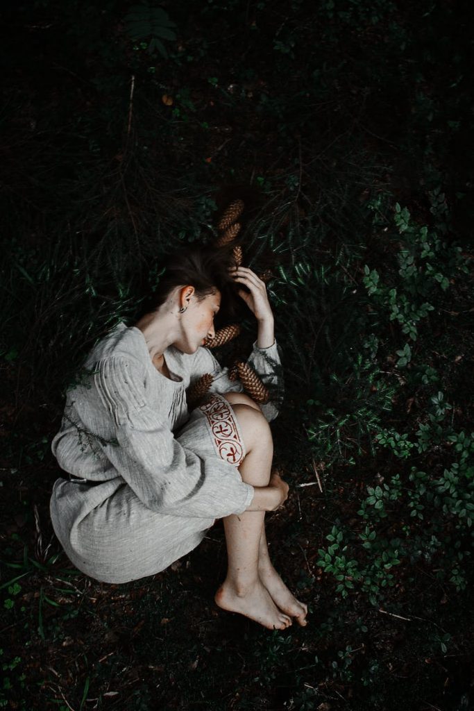 woman lying on the ground in fetal position