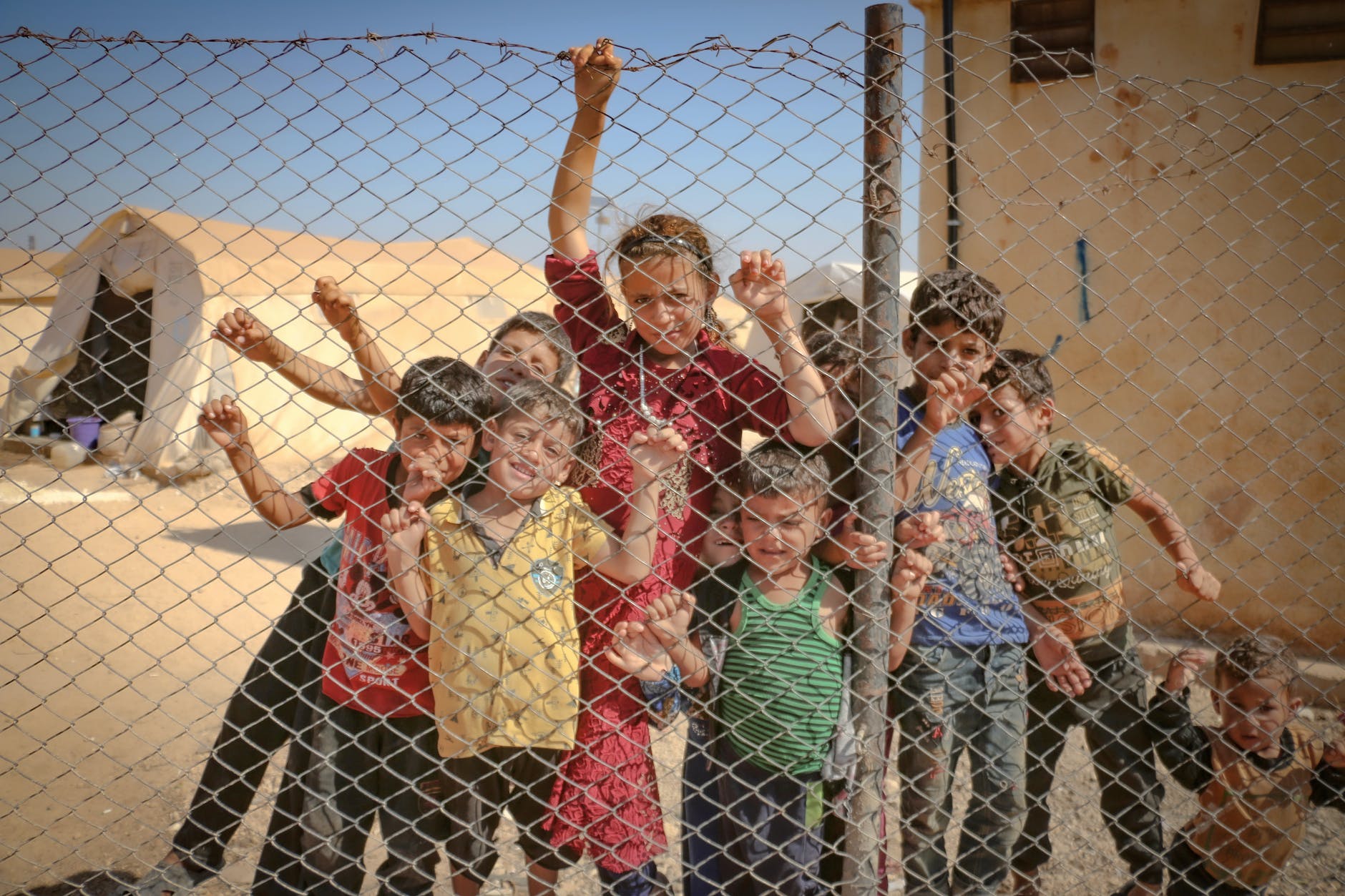 kids behind a chain link fence