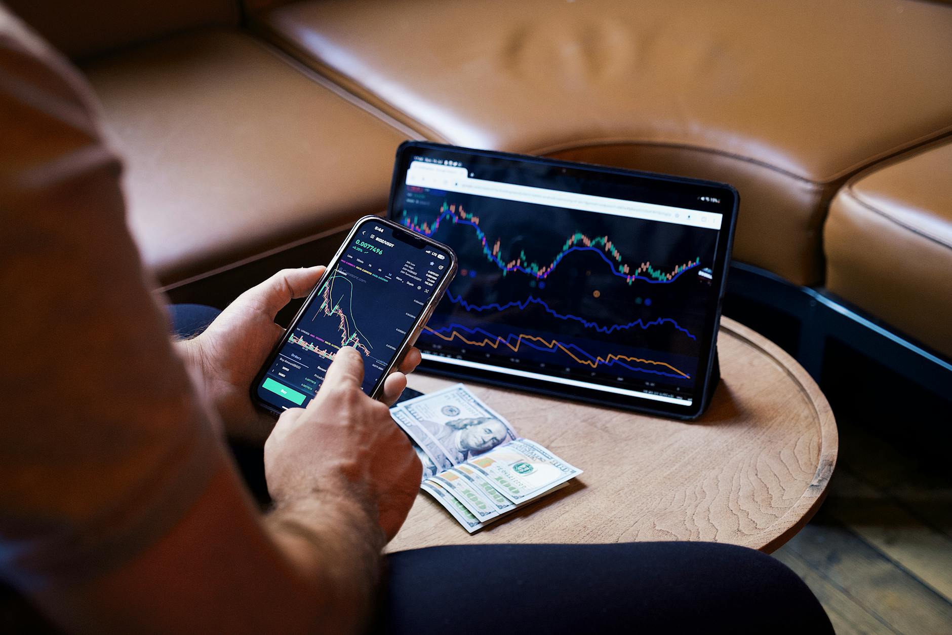 man looking at the stock charts on the phone and tablet - how the world works